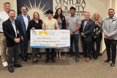 Staff with scholarship winner and check